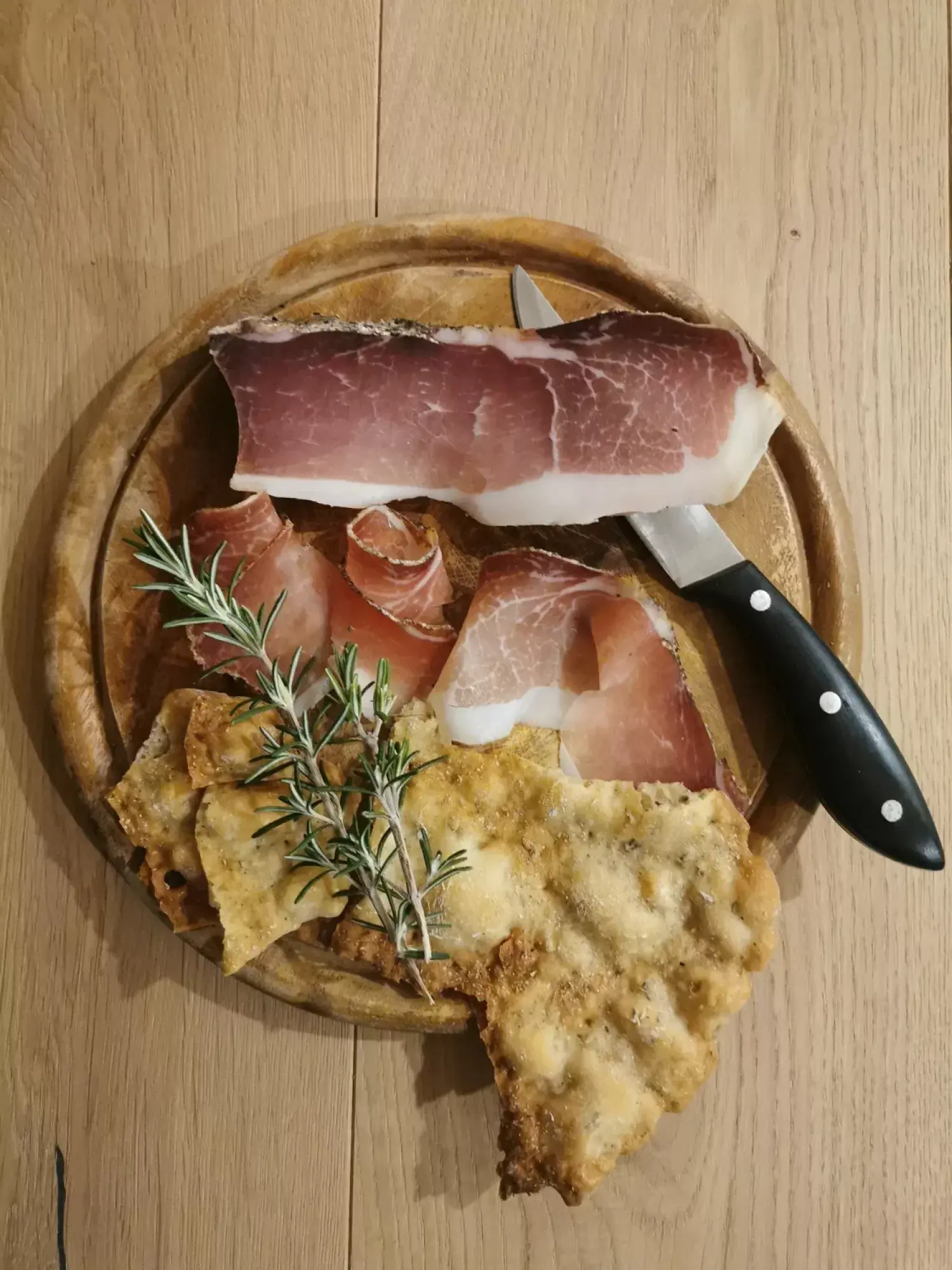 Hausgeräucherter Speck mit Messer und Schüttelbrot auf dem Holzbrett