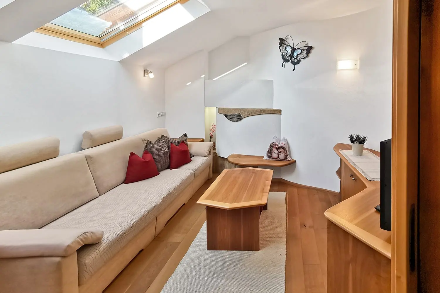 Wohnraum mit heller Couch unter dem Dachfenster
