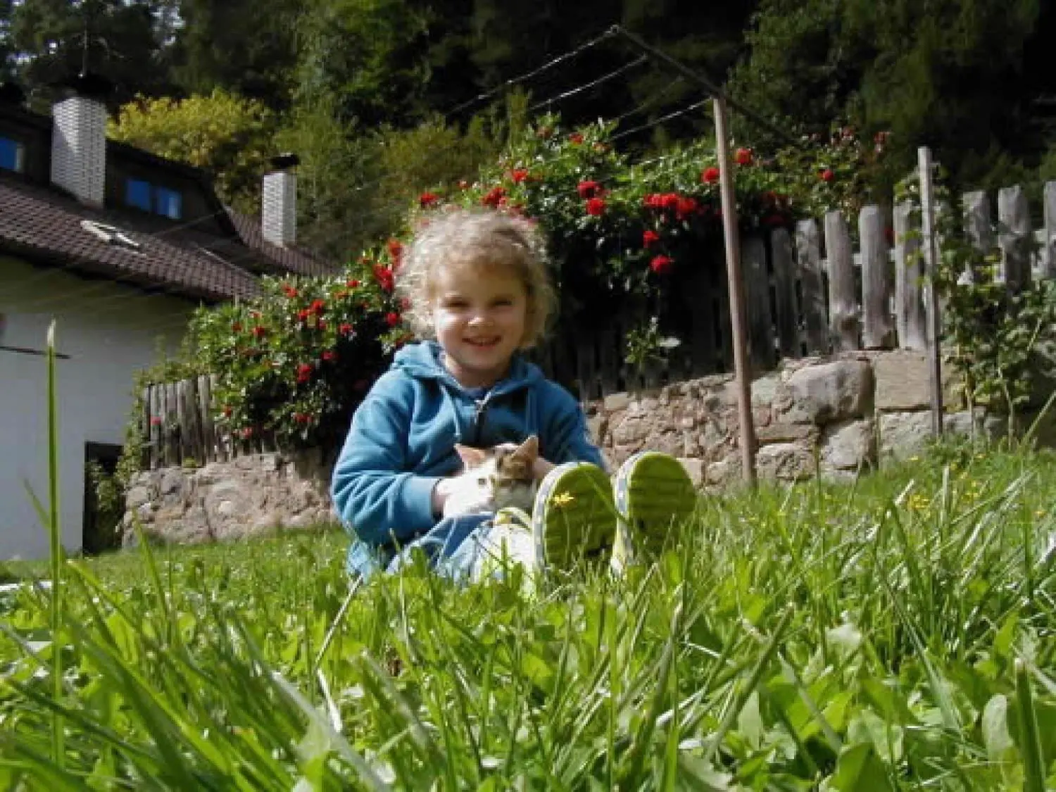 Mädchen mit Kätzchen im Garten des Neuhofs