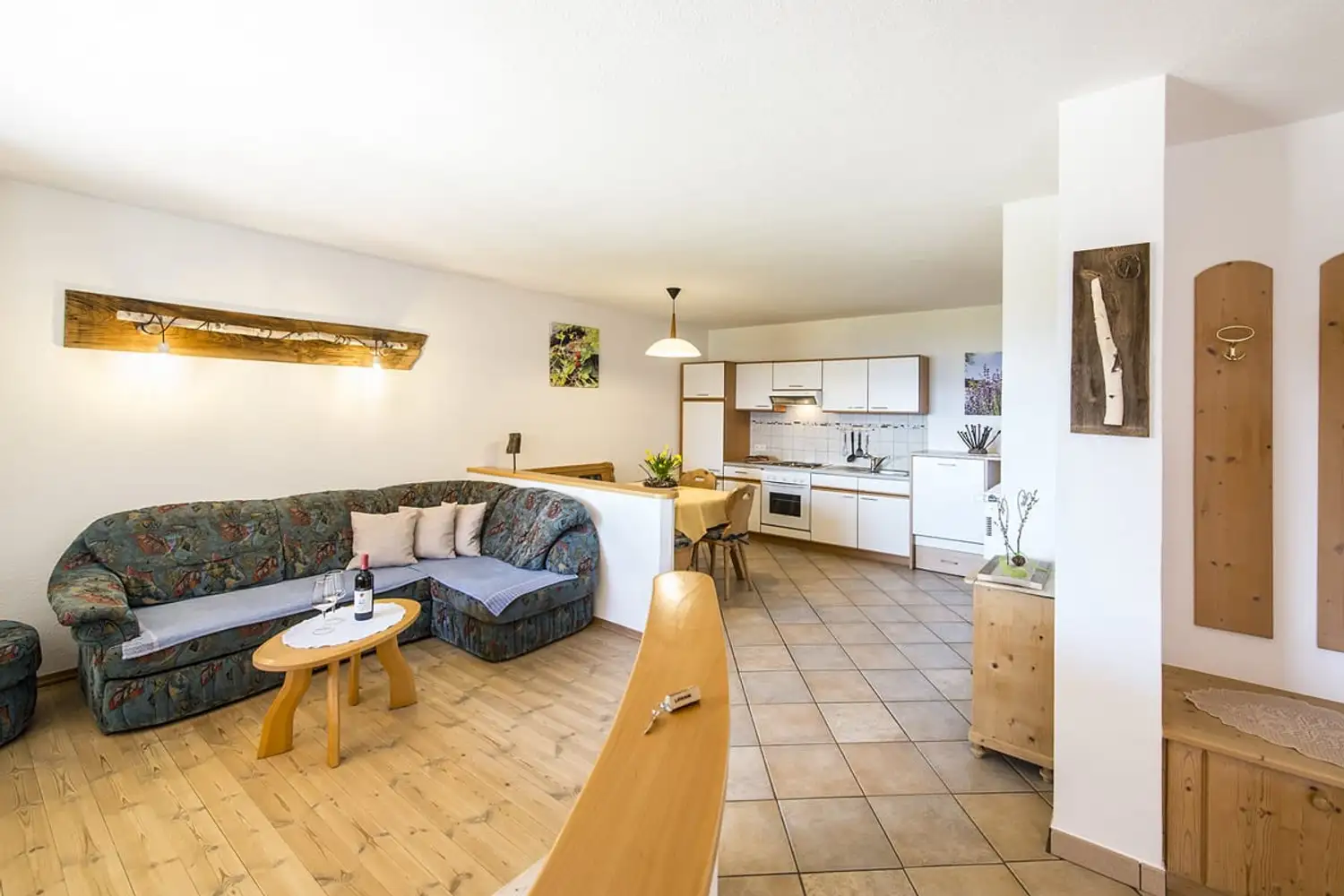 Wohnraum mit Sofa, Couchtisch und offener Küche